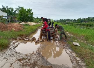Babinsa Koramil Rawajitu Bersama Warga Timbun Jalan Rusak.